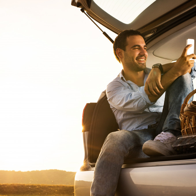 Man in carbooth taking selfie