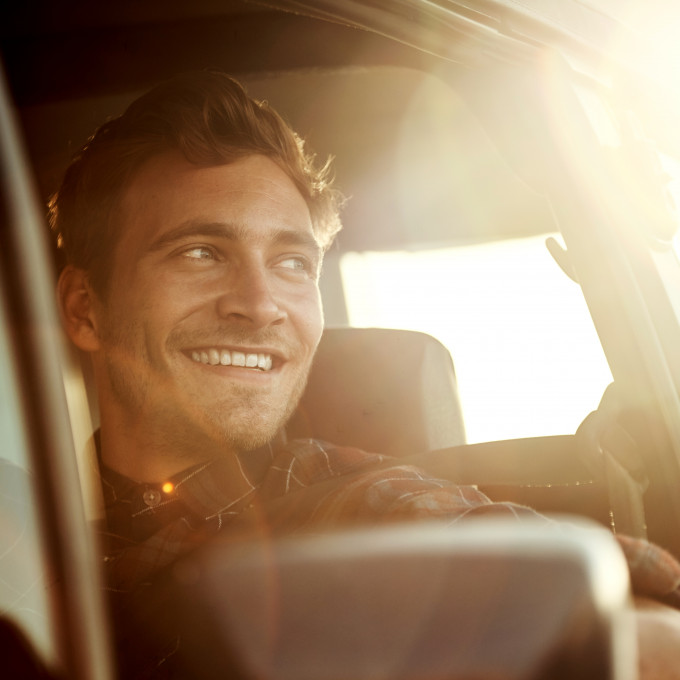 Man smiling in car sundown