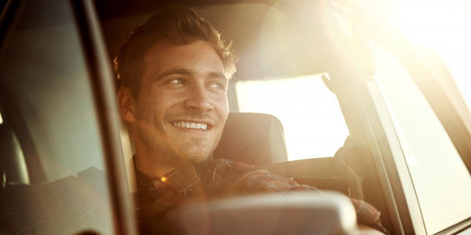 Man smiling in car sundown