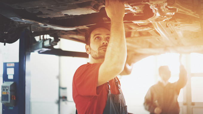 Mechanic checken the underside of the car