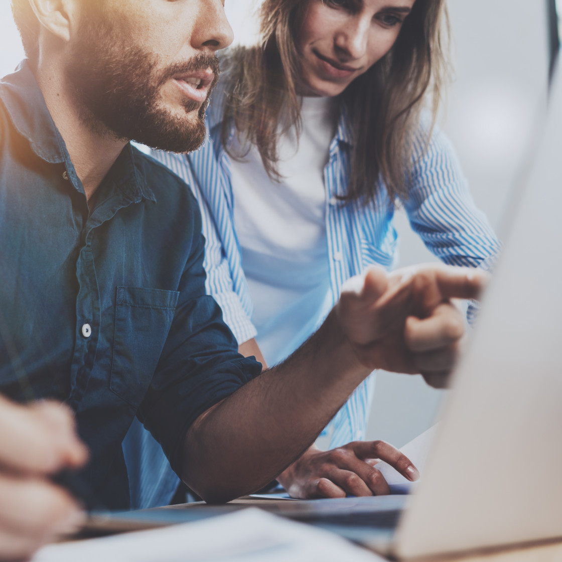 man pointing at laptop woman