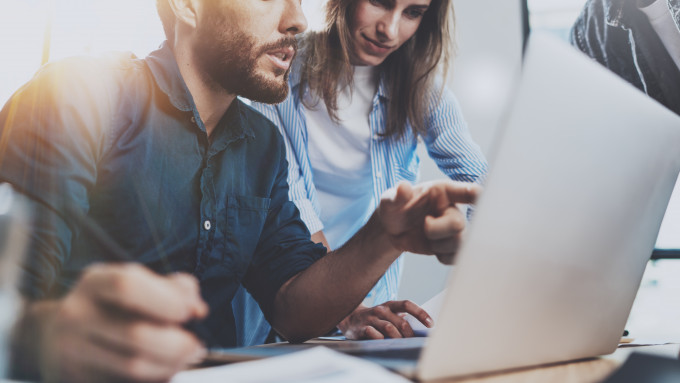 man pointing at laptop woman