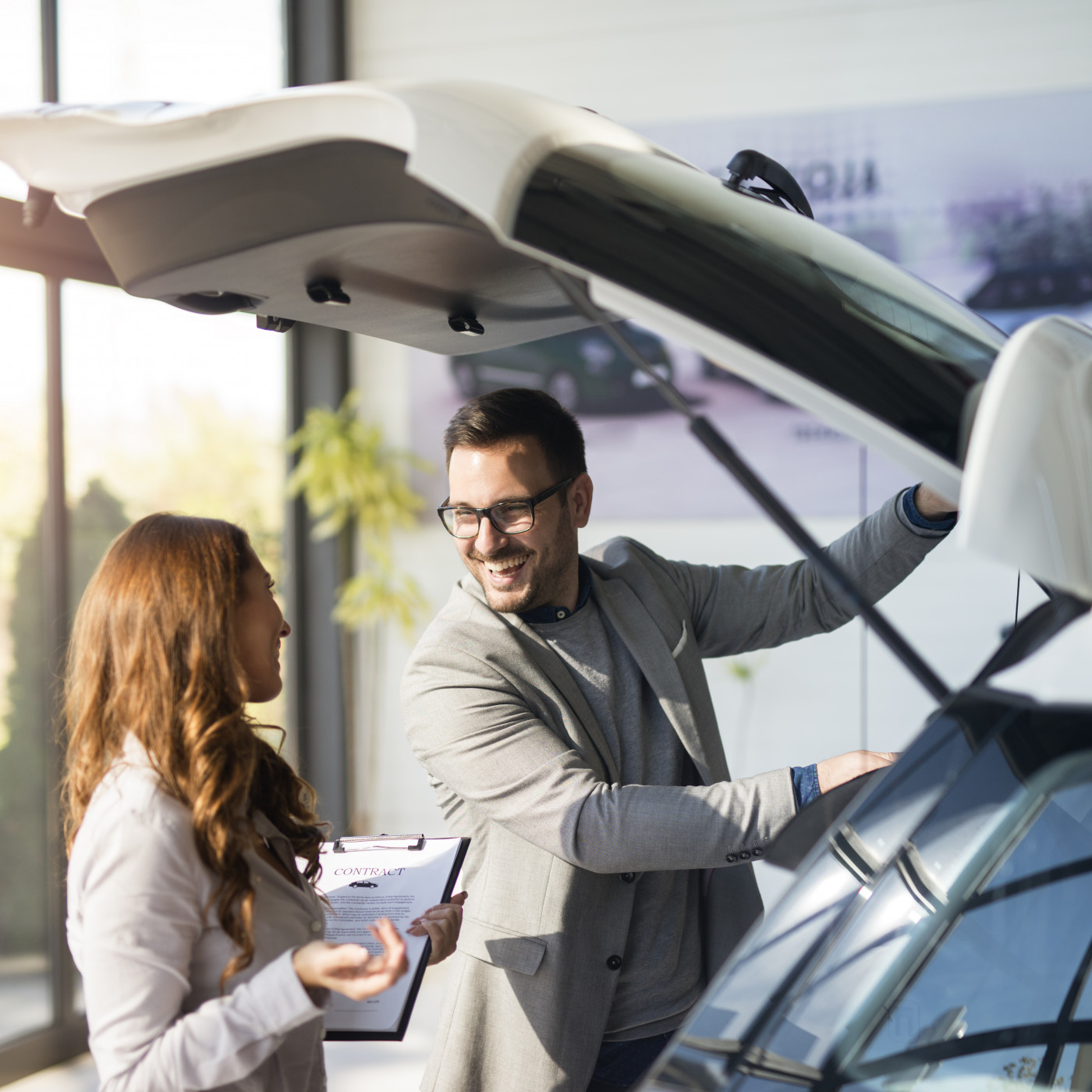 car buyer testing trunk space new car local vehicle dealership showroom