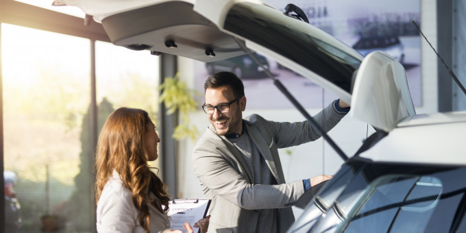 car buyer testing trunk space new car local vehicle dealership showroom