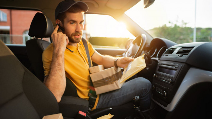 Large Delivery man in a courier car